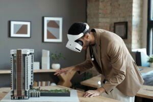 Young architect in vr headset bending over house layout